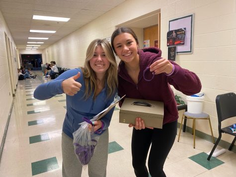 Freshman Anna Beers and sophomore Raegan LaCross selling bracelets to peers to raise money for the Epilepsy Foundation of Michigan. 