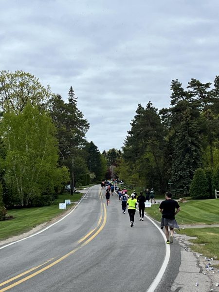 Athletes from both the marathon and the half marathon run down East Shore Road during the Bayshore Marathon. Photo Credit: M. Gartland