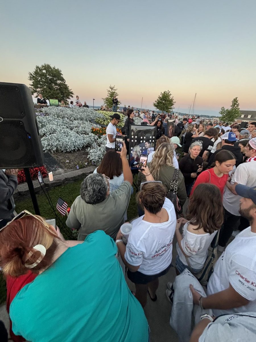 Attendees of the prayer vigil for Charlie Kirk and his family gather around photos of Kirk and his wife. Those who attended wished to show respect for the man they admired. “He was committed to having conversations so we could better understand each other and keep our disagreements from getting violent. He was committed to sharing his testimony with others so they could share in the joy he found in his life through his faith,” Claar said. 