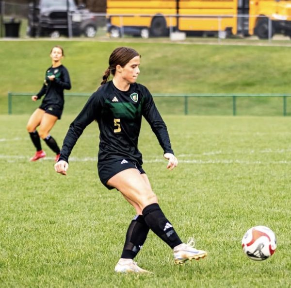 Kicking the ball, sophomore Noelle Peron plays center back keeping the ball away from any opponents. Peron and her teammates work together to try and score a goal against the other team.